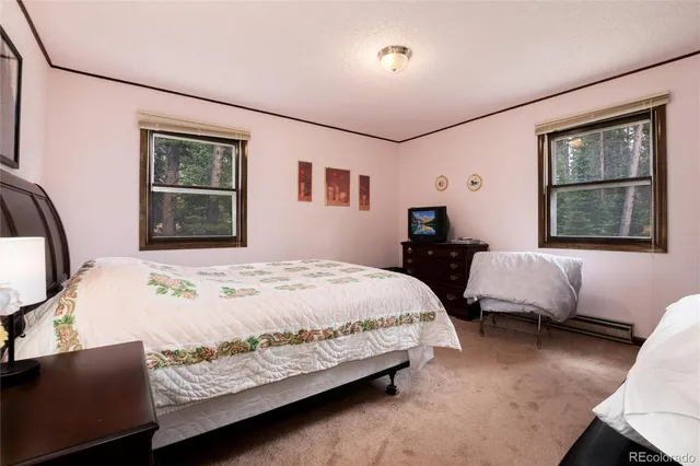 a bedroom with a bed window and dresser