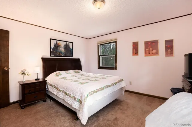 a bedroom with a bed and a wall painting