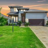 a view of a house with a yard and pathway