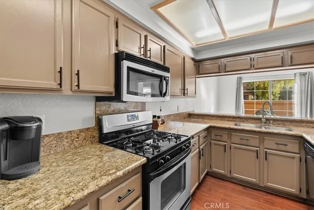 a kitchen with stainless steel appliances granite countertop a stove microwave and sink