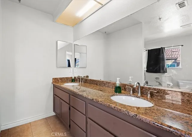 a bathroom with a granite countertop sink and a mirror