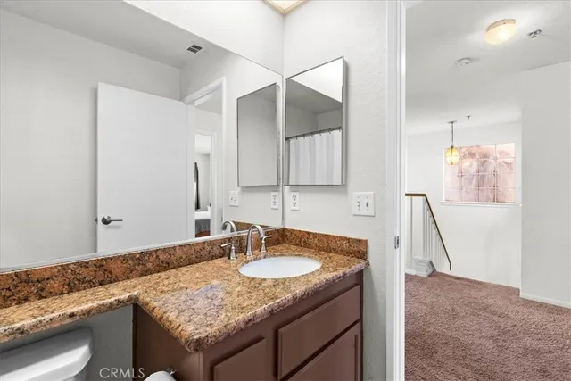 a bathroom with a granite countertop sink and a mirror