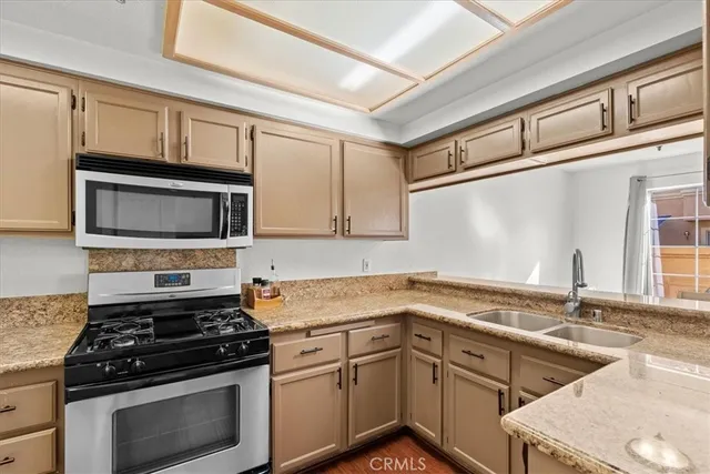 a kitchen with stainless steel appliances granite countertop a sink stove and microwave