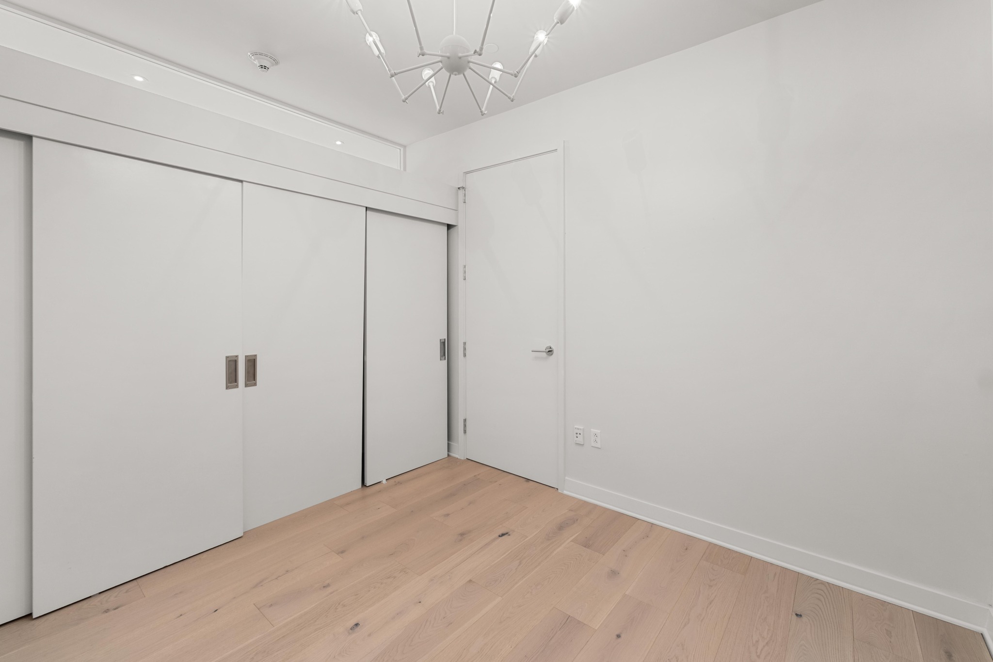 210 Lavaca Street, Unit 1810 Austin, TX 78701 - Photo 19 of 28 Unfurnished bedroom with light wood finished floors, a closet, and hanging lights