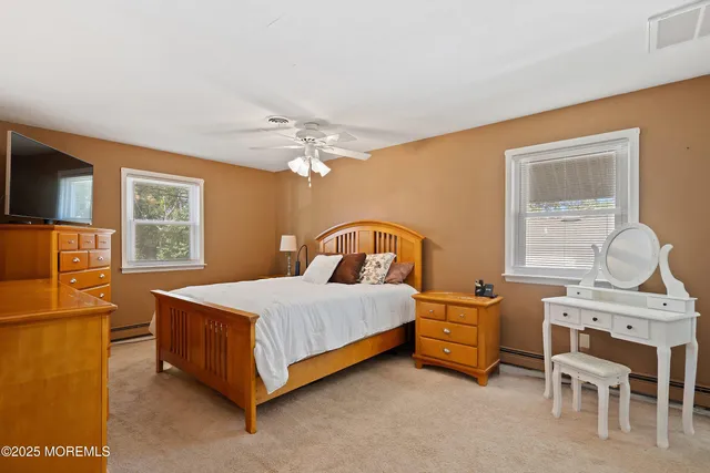 a bedroom with a bed next to a window with pc on the wall