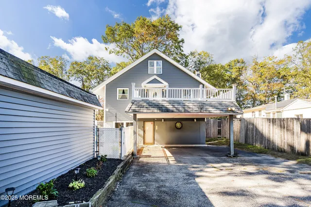 a view of a house with a yard and potted plants