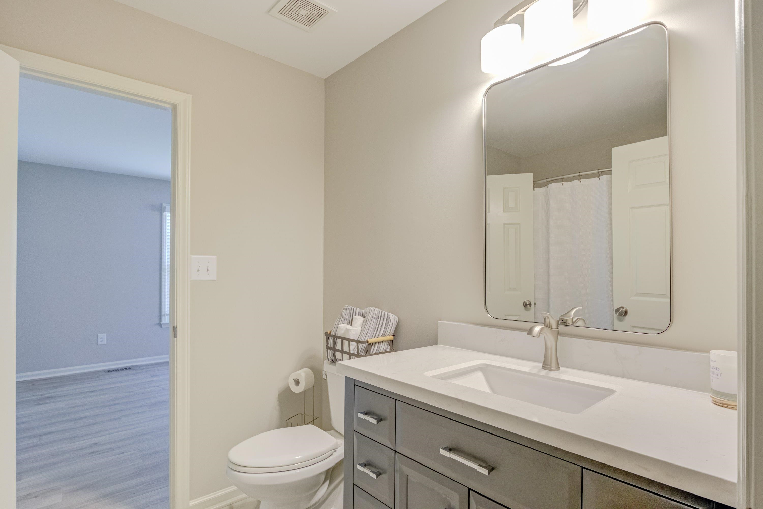 100 Wythe Circle Raleigh, NC 27615 - Photo 24 of 46 New vanity, cultured marble countertop with brushed nickel faucet. New Revive Carrera Vinyl floor. New vanity lighting. New brushed nickel vanity mirror. First floor full bathroom