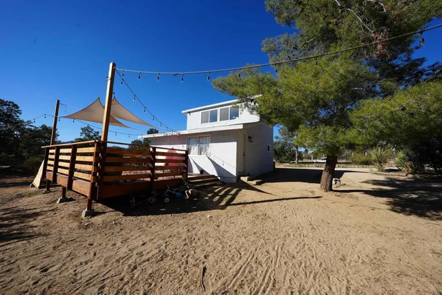 a view of a house with backyard and trees