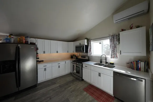 a kitchen with refrigerator cabinets and wooden floor