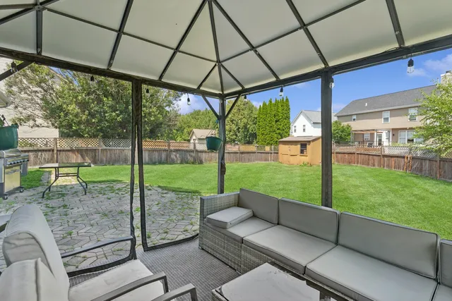 a view of a patio with a table chairs and backyard