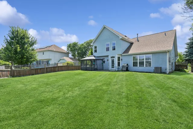 a view of house with a big yard and potted plants