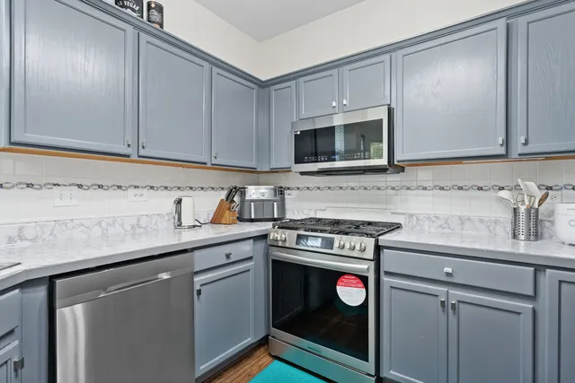 a kitchen with stainless steel appliances granite countertop a sink stove and microwave