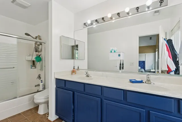 a bathroom with a double vanity sink toilet and shower