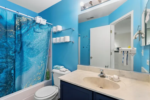 a bathroom with a sink vanity mirror and toilet