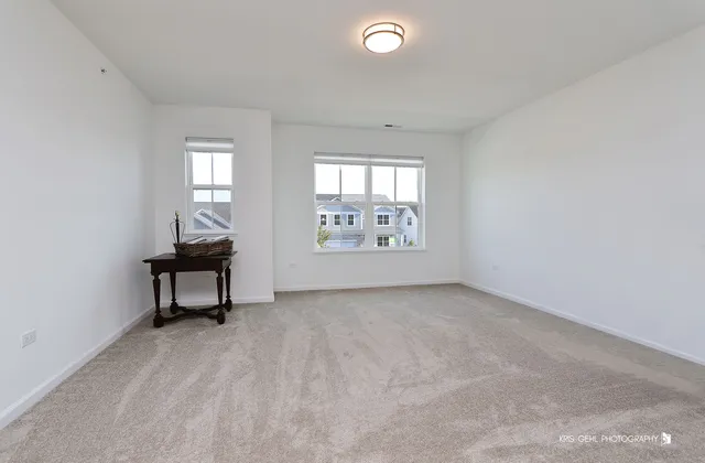 a view of an empty room with a window and a kitchen