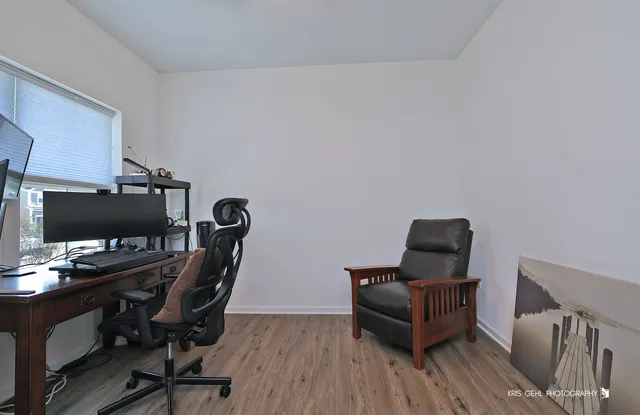 a view of a workspace with furniture and a window