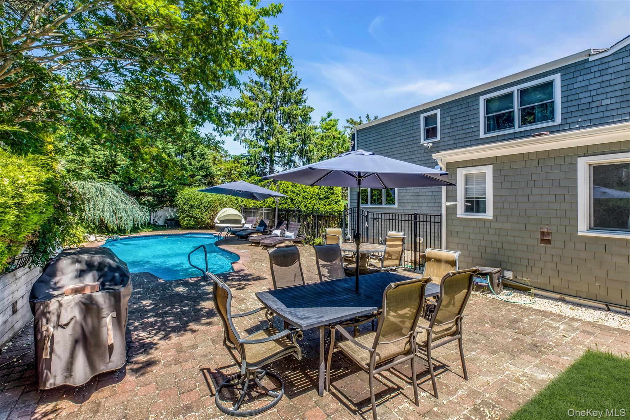 345 Colonial Road Southold, NY 11971 - Photo 36 of 43 a view of a patio with a table and chairs under an umbrella