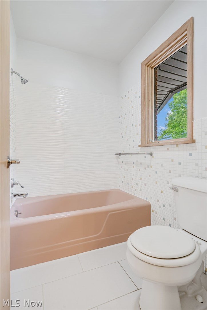 1010 Knollwood Road Northwest Canton, OH 44708 - Photo 26 of 47 Bathroom featuring toilet, tile flooring, tile walls, and shower / bathtub combination