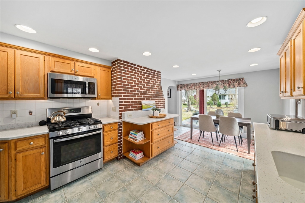 236 High Street Canton, MA 02021 - Photo 5 of 25 a kitchen with stainless steel appliances granite countertop a stove top oven a sink a dining table and chairs