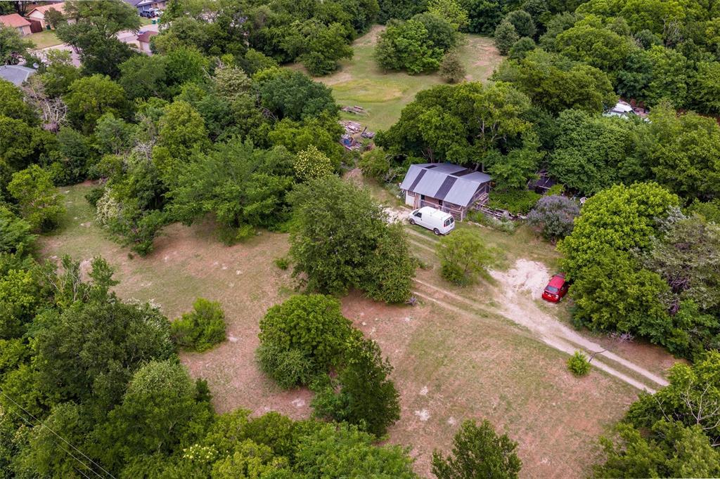 1007 West Belt Line Road Cedar Hill, TX 75104 - Photo 26 of 30 Wooded acreage featuring a barn-style structure with a metal roof, surrounded by mature trees and open clearings