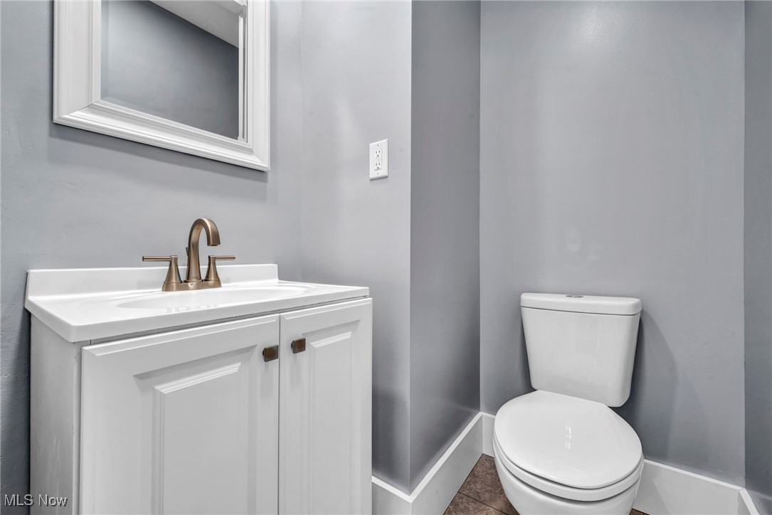 1610 Spring Road Old Brooklyn, OH 44109 - Photo 15 of 38 Half bathroom with tile patterned flooring, baseboards, vanity, and toilet