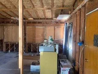 a room with water heater and wooden cabinets