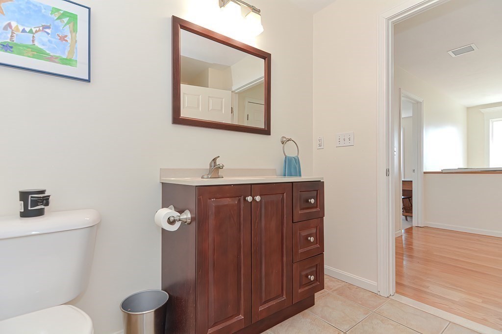 82 Swift Road Framingham, MA 01702 - Photo 33 of 39 a bathroom with a toilet a sink and mirror