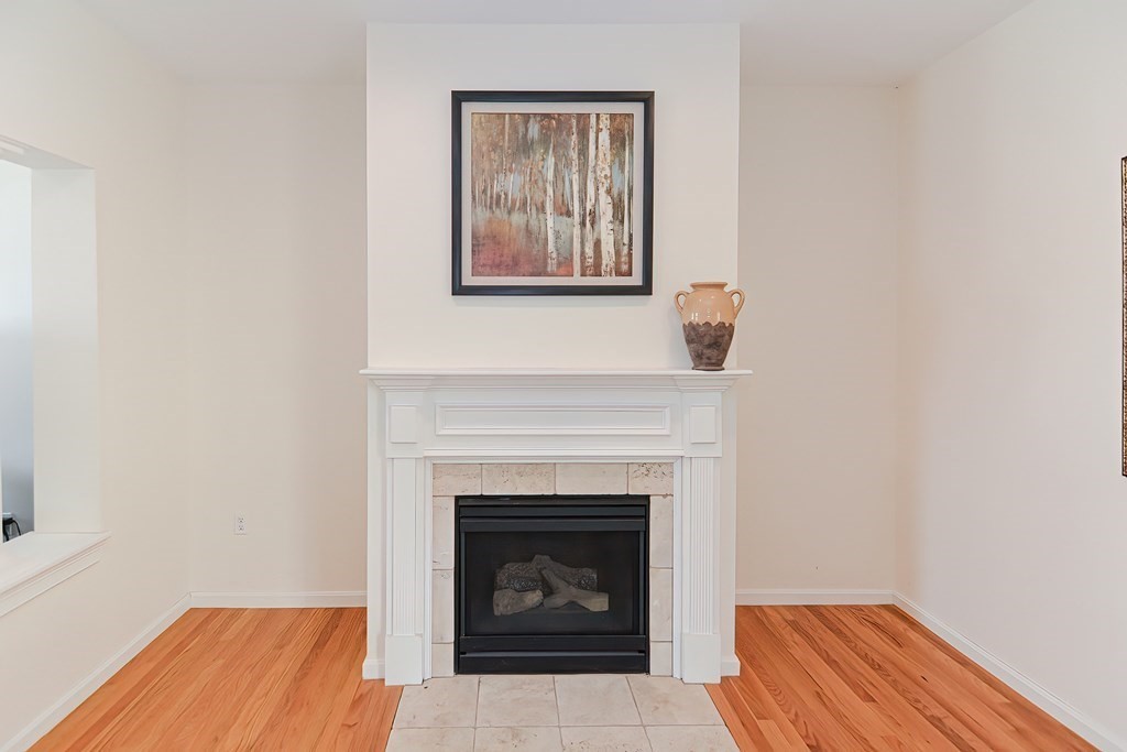 82 Swift Road Framingham, MA 01702 - Photo 9 of 39 a living room with a fireplace and a wooden floor