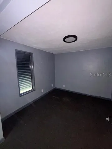 a view of a room with an empty space and a window