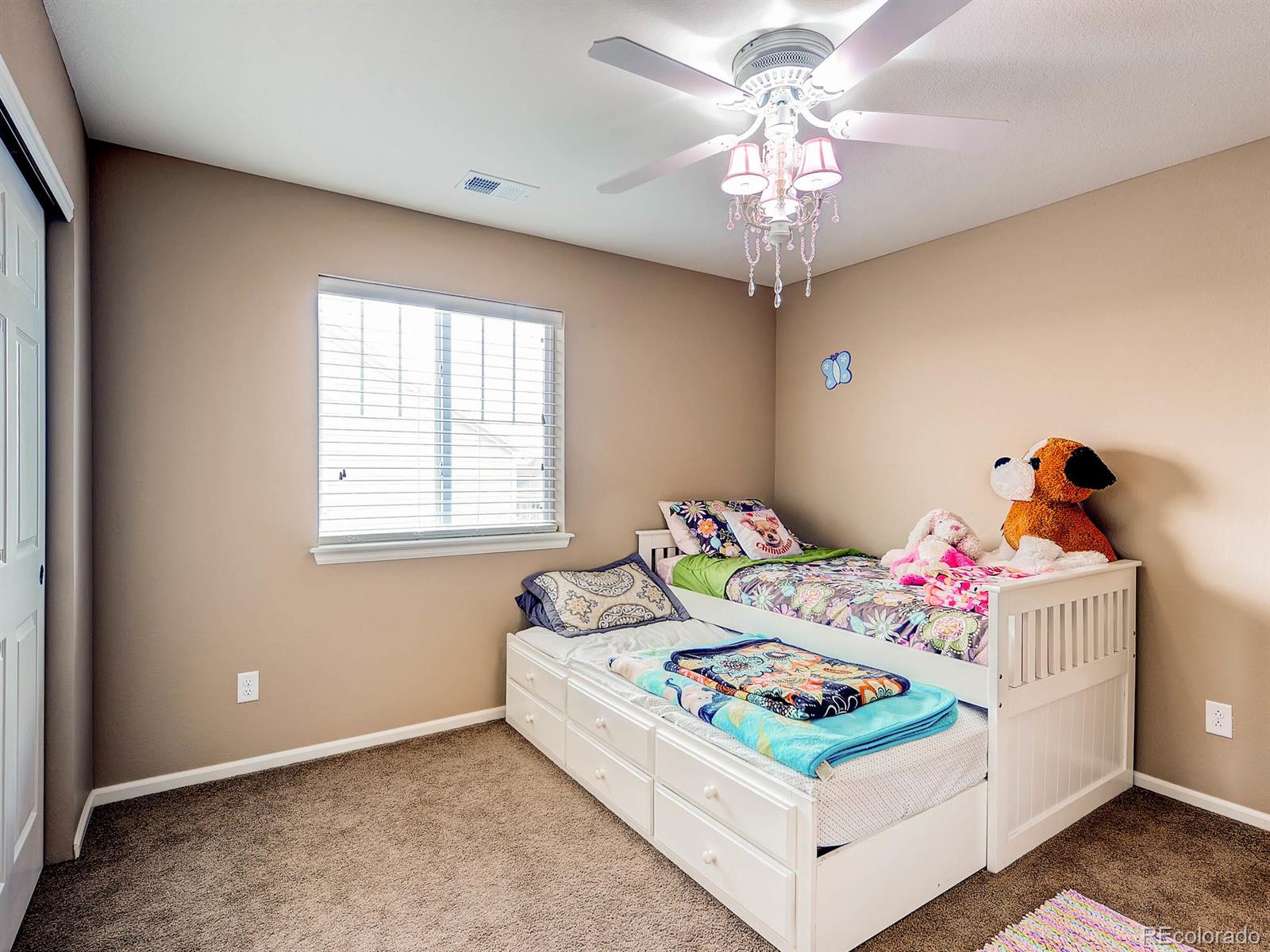 714 Springvale Road Castle Rock, CO 80104 - Photo 21 of 28 a bedroom with a bed and a chandelier