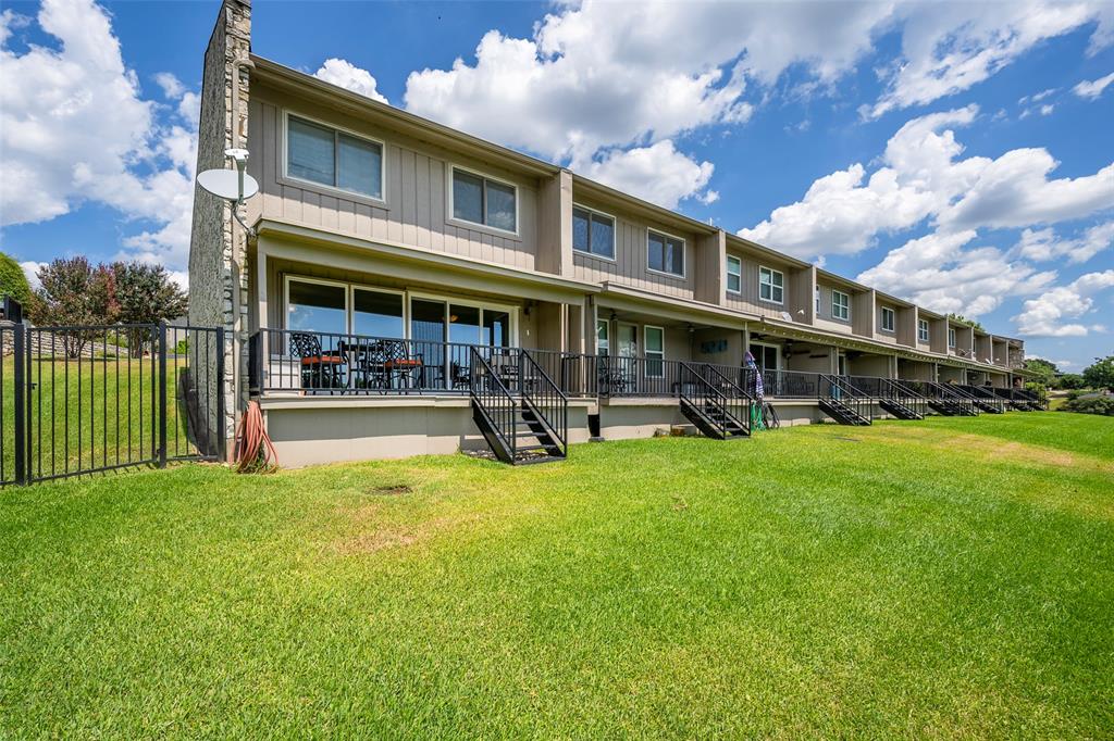 Rear view of property with board and batten siding, a yard, stairway, a chimney, and a porch