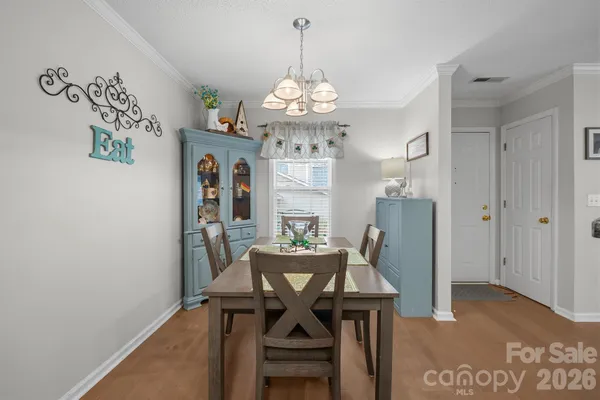 a view of a dining room with furniture a chandelier and wooden floor
