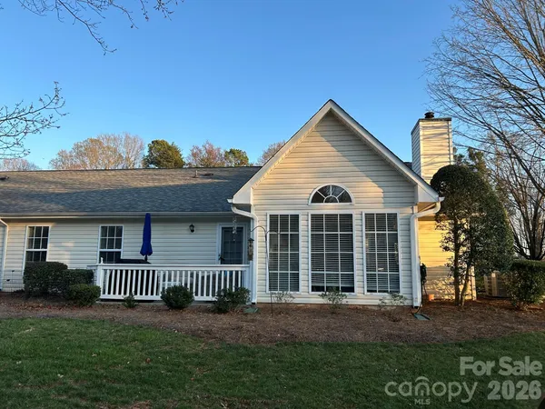 a view of a brick house with a yard and large trees