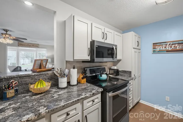 a kitchen with sink a stove and cabinets