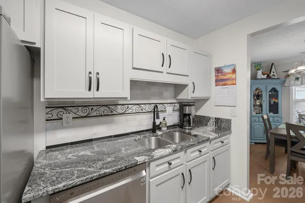 a kitchen with stainless steel appliances granite countertop a sink stove and cabinets