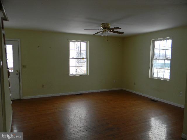 3922 North Point Road Baltimore, MD 21222 - Photo 5 of 22 a view of an empty room with wooden floor and a window
