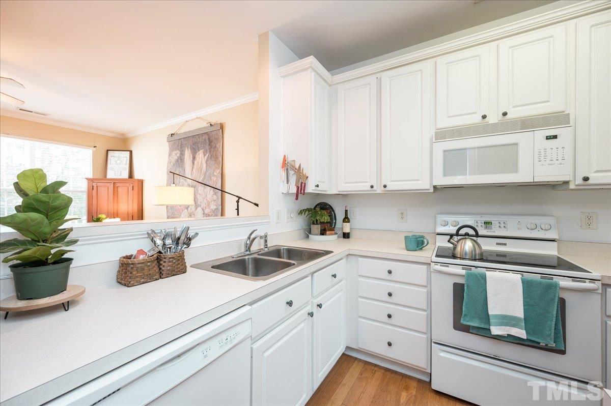 8342 City Loft Court Raleigh, NC 27613 - Photo 11 of 23 a kitchen with white cabinets and white appliances