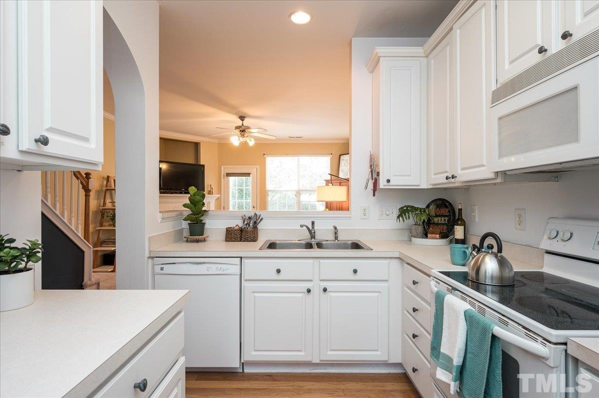 8342 City Loft Court Raleigh, NC 27613 - Photo 7 of 23 a kitchen with granite countertop a sink a stove and cabinets