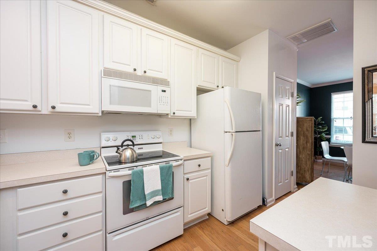 8342 City Loft Court Raleigh, NC 27613 - Photo 10 of 23 a kitchen with stainless steel appliances white cabinets and a refrigerator