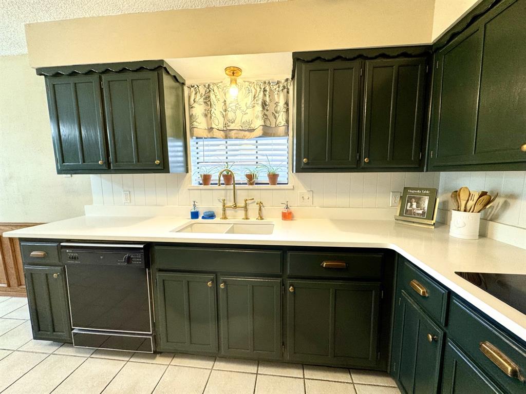 113 Northeast Timber Ridge Drive Burleson, TX 76028 - Photo 16 of 36 Magnolia-Inspired dark green kitchen cabinetry with brass hardware, white Quartz countertops, and beadboard backsplash... Dishwasher & Disposal too!