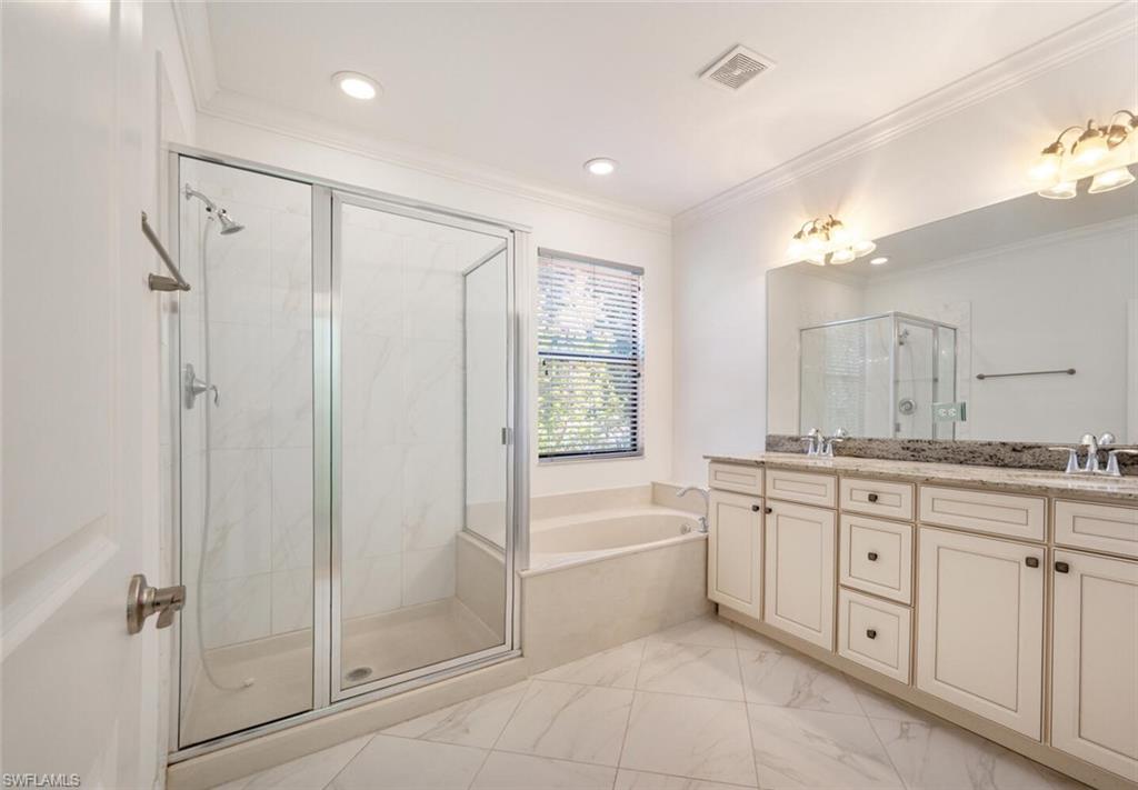 7761 Bristol Circle Naples, FL 34120 - Photo 15 of 32 a bathroom with a granite countertop sink a large mirror and a bathtub