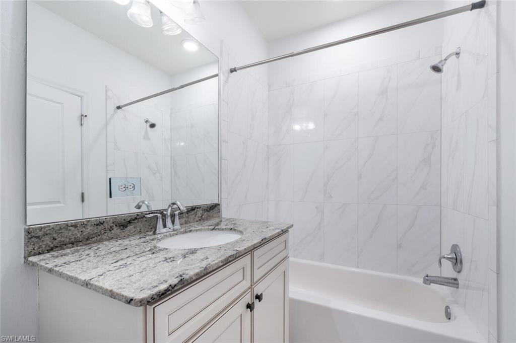 7761 Bristol Circle Naples, FL 34120 - Photo 18 of 32 a bathroom with a granite countertop sink and a mirror