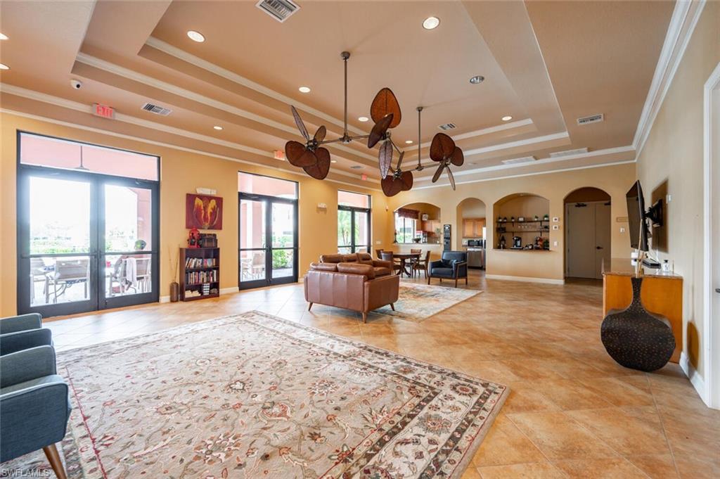 7761 Bristol Circle Naples, FL 34120 - Photo 25 of 32 a living room with furniture a chandelier and large windows