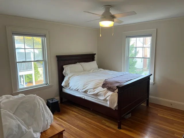 a bed sitting in a bedroom next to a window