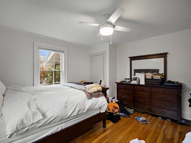 a bedroom with a bed and a mirror on dresser
