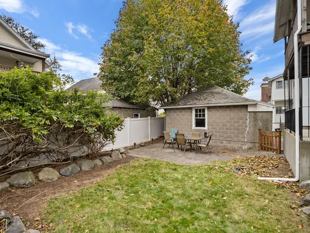 a backyard of a house with table and chairs