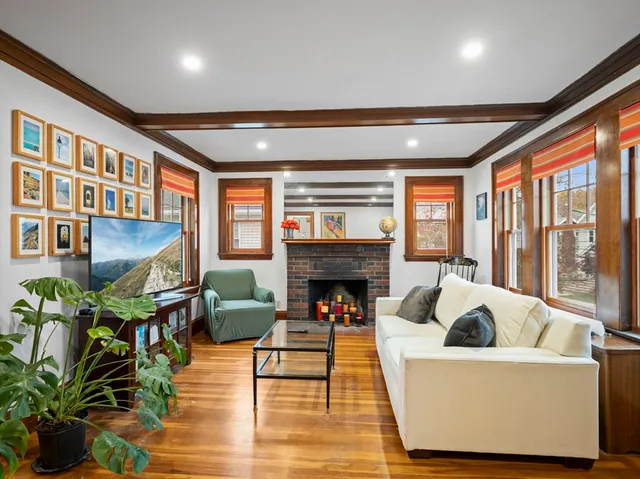 a living room with furniture fireplace and a large window