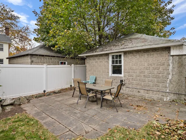 a backyard of a house with table and chairs