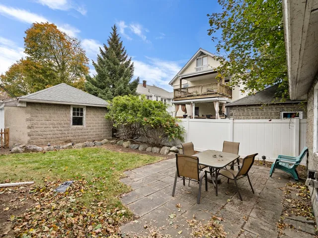 a backyard of a house with table and chairs