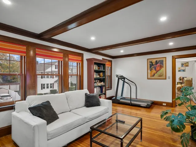 a living room with furniture a ceiling fan and a large window